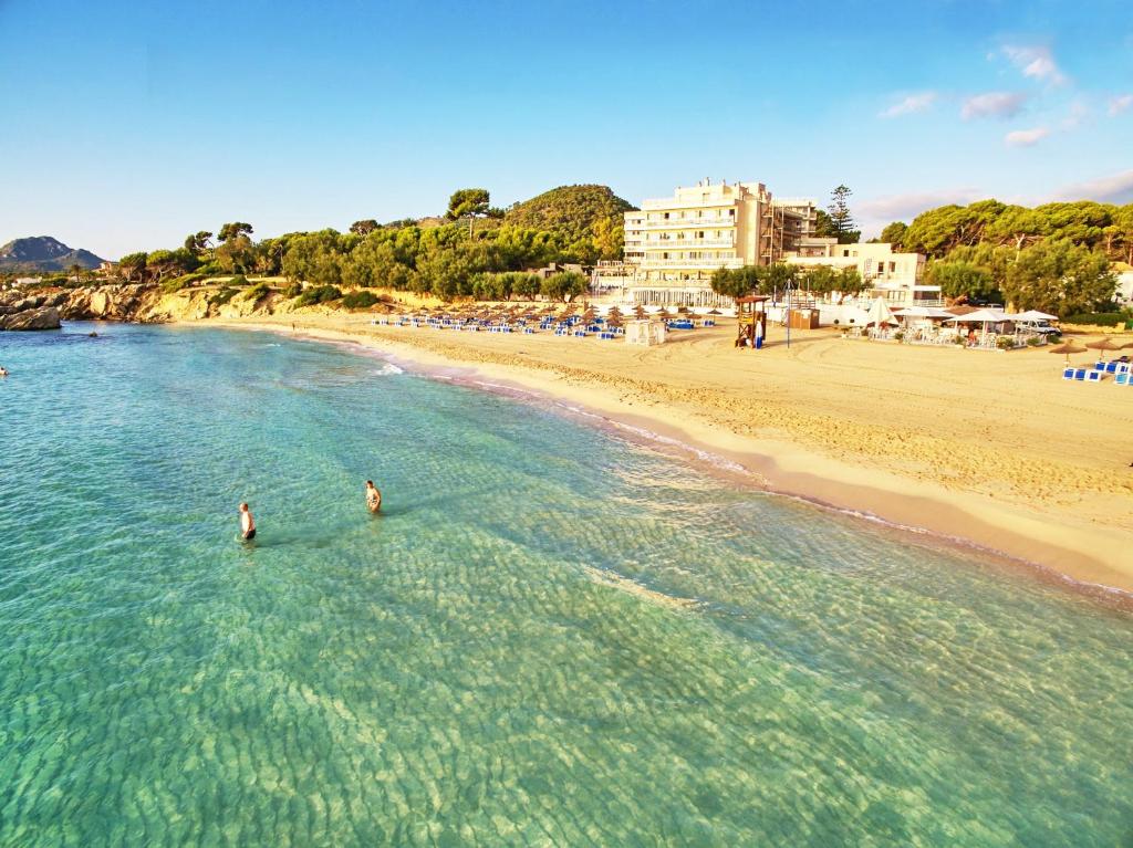 two people standing in the water at a beach at Hotel Na Forana in Cala Ratjada