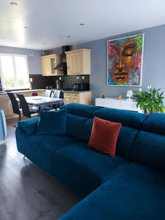 a living room with a blue couch and a kitchen at au pont vieux in Chanac