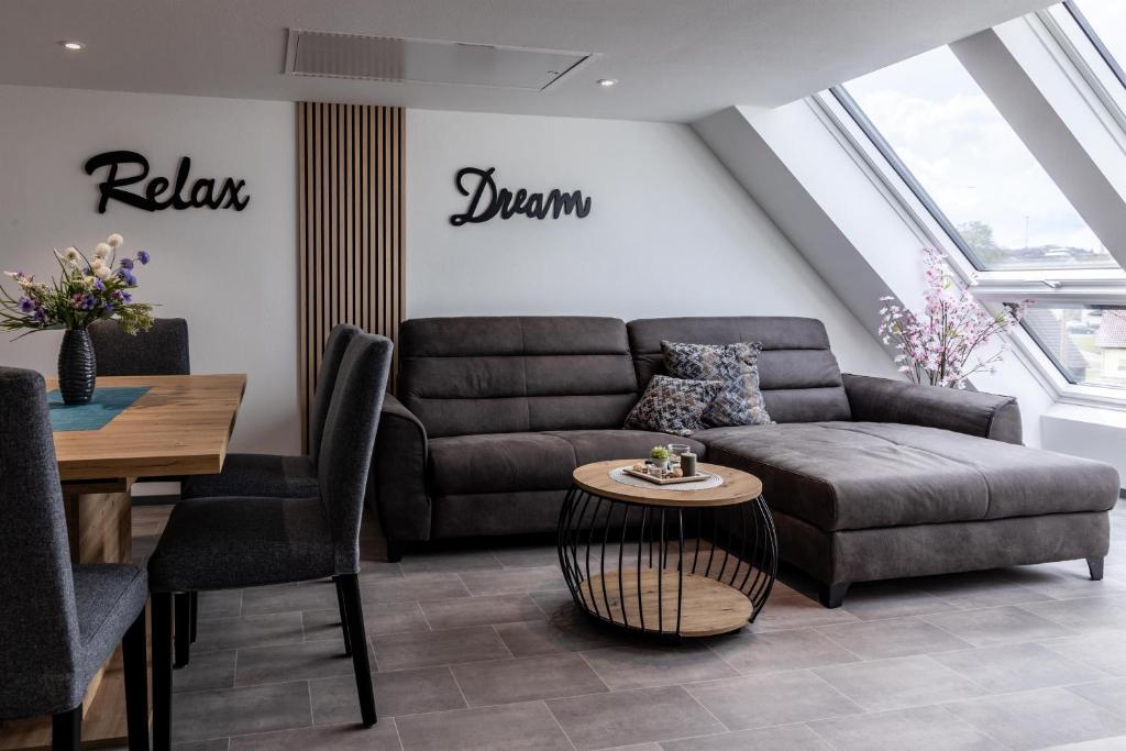 a living room with a couch and a table at Asweiler Landliebe - klimatisierte Premiumfewo mit Balkon und Fernblick in Freisen