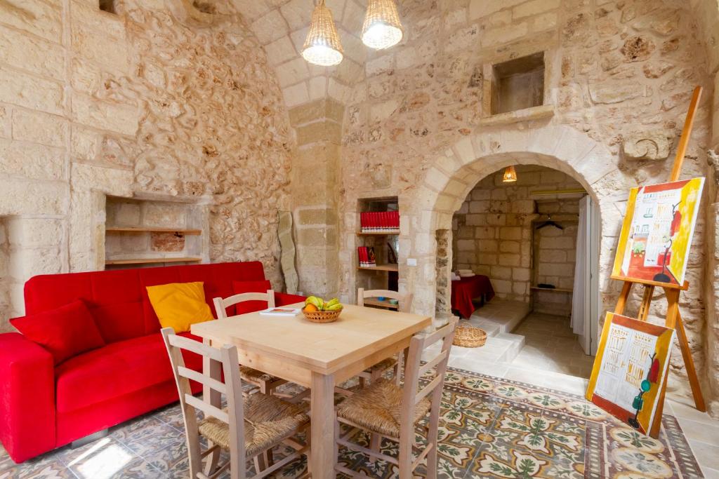 a living room with a red couch and a table at GuestHost - La Pizzica Apartment in Cannole