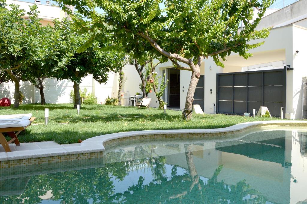 ein Pool vor einem Haus mit Bäumen in der Unterkunft Percebes Exclusive B&B in Cutrofiano