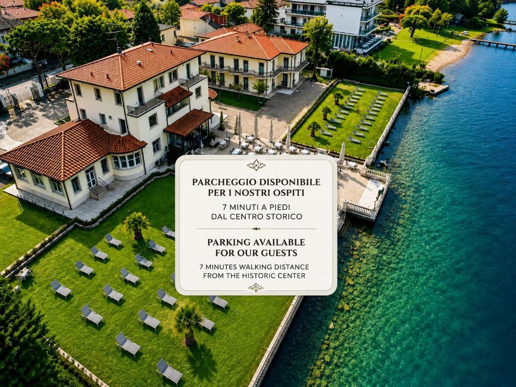 a sign in front of a house next to the water at Hotel Villa Trieste in Sirmione