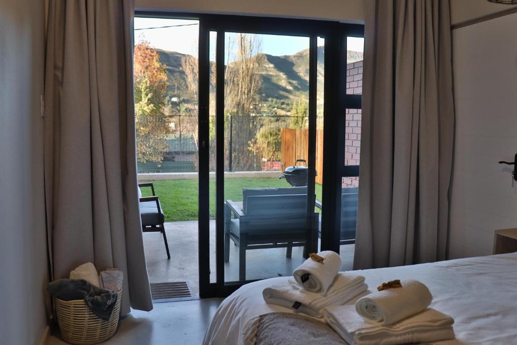 a bedroom with a bed and a view of a patio at Mon Cheri Clarens in Clarens