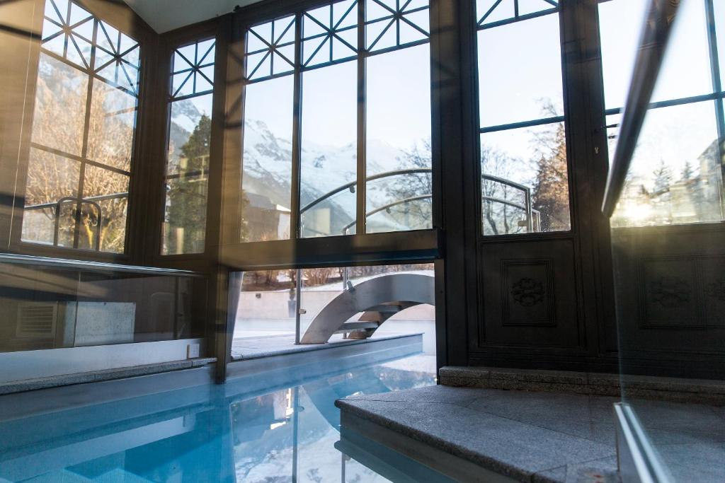 a building with a swimming pool and windows at Hôtel Mont-Blanc Chamonix in Chamonix