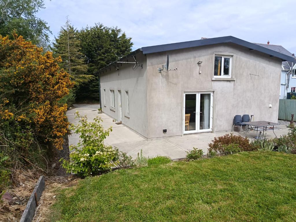 a small white house with a patio in the yard at Countryside bliss in Clonakilty