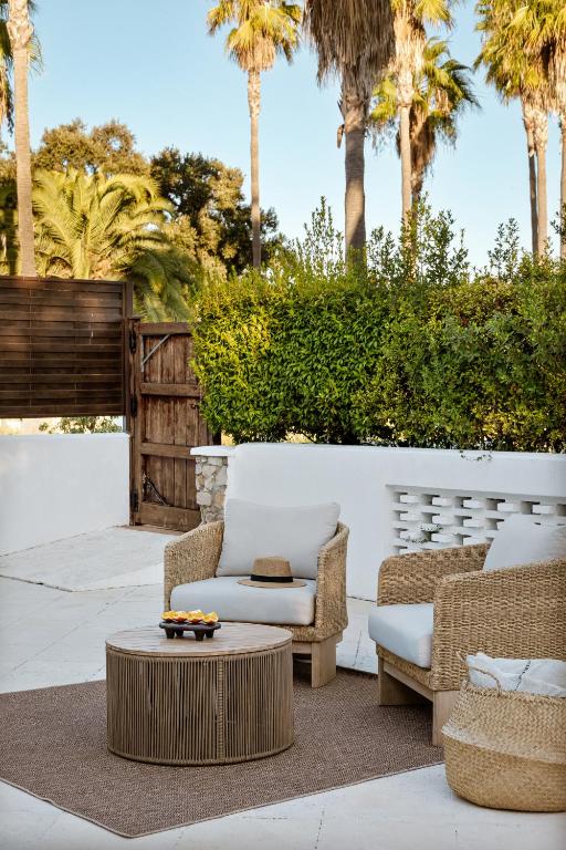 a patio with two chairs and a coffee table at Hotel Encinar de Sotogrande in Sotogrande