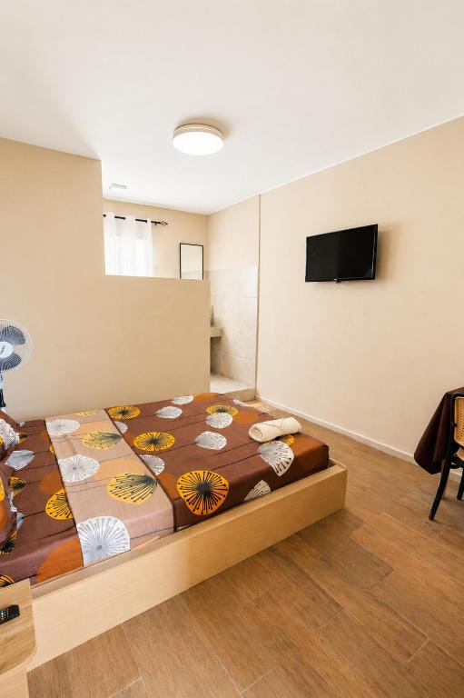 a bedroom with a bed and a flat screen tv at Soleya in Antananarivo