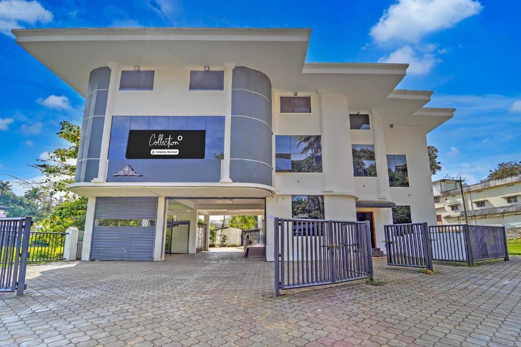 a large white building with a sign on it at Super Collection O RTO Office Uzhavoor Formerly Hotel Zodiac in Puduveli