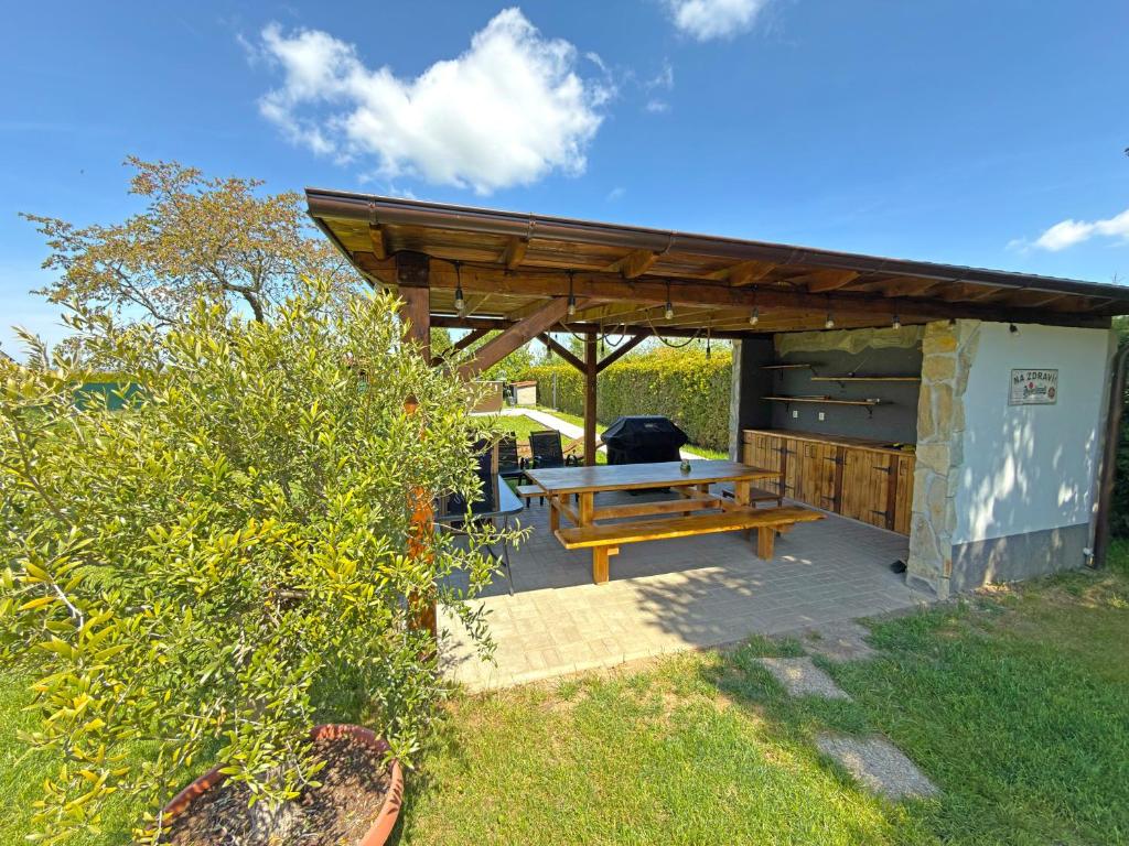 a picnic table under a wooden pavilion in a yard at Pension U Babi in Chrášťany