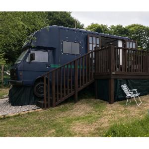 a blue truck parked next to a deck with a house at Wake up with Wallabies in Par