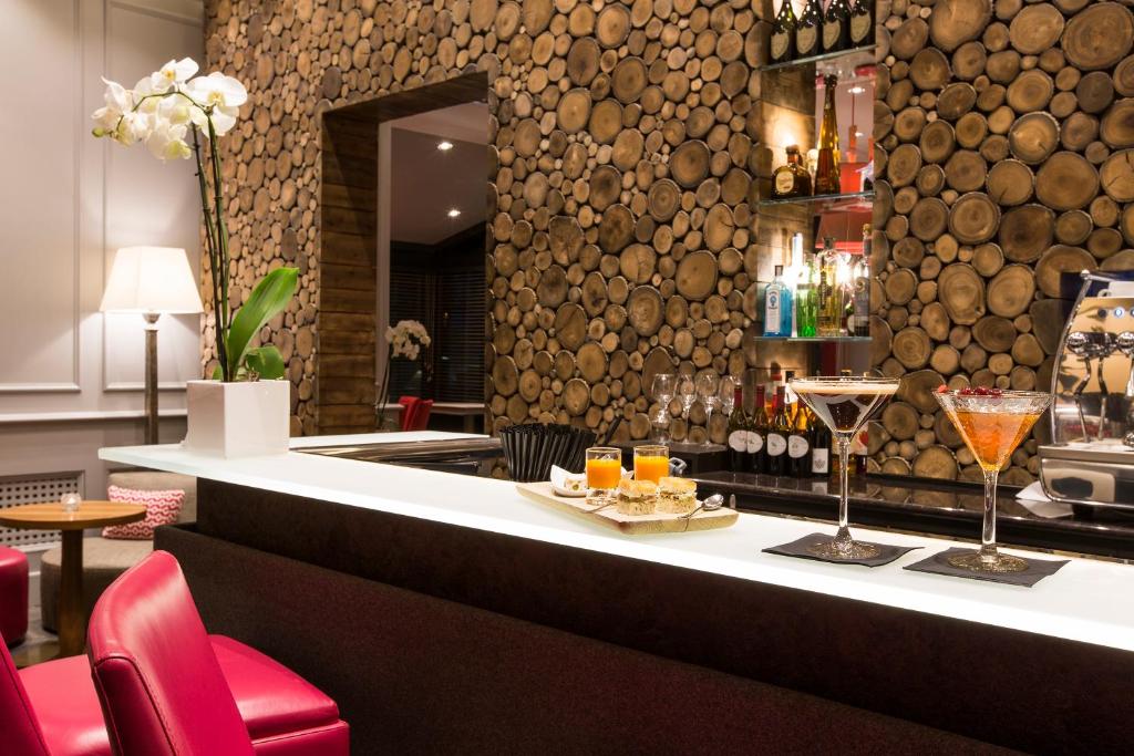 a bar in a restaurant with a counter with glasses at Hôtel Mont-Blanc Chamonix in Chamonix