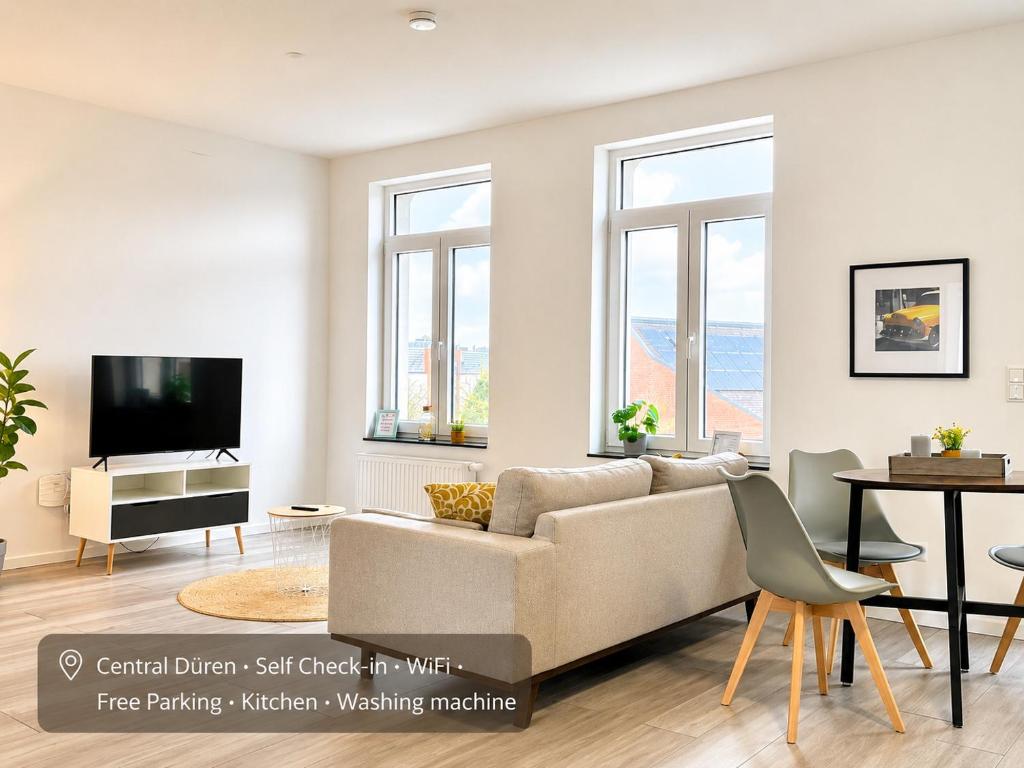 a living room with a couch and a tv at Der Schwan, Innenstadt, 2022 renoviert in Düren - Eifel