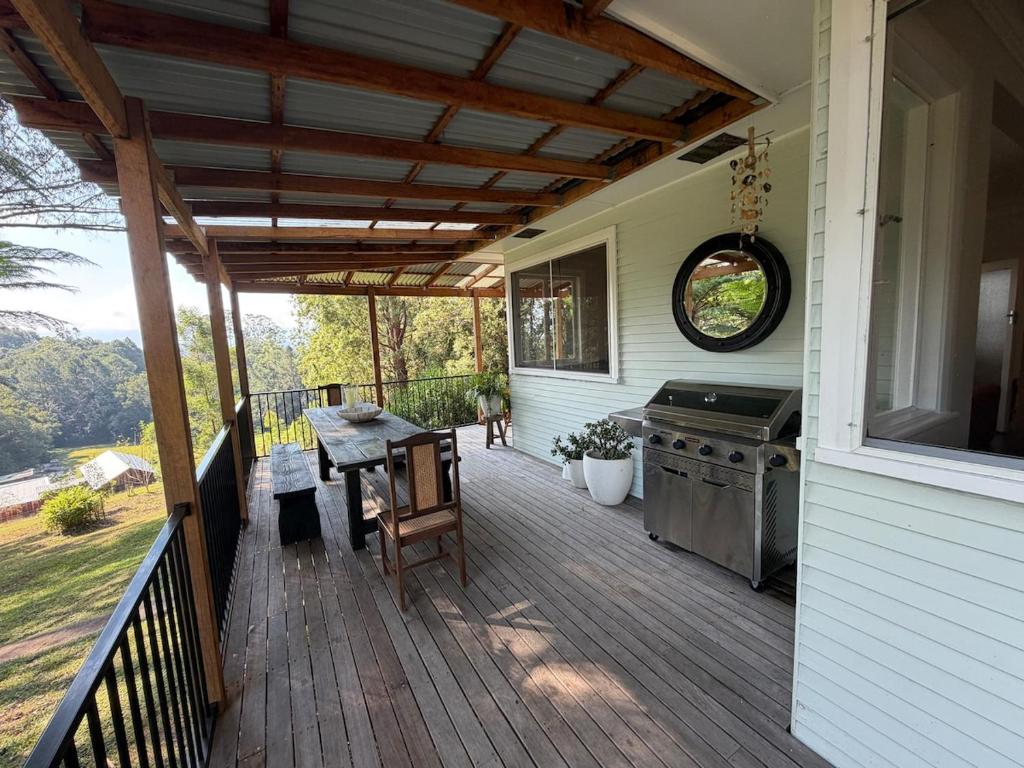 a patio with a table and a grill on a house at Hoop Lodge in Bellingen