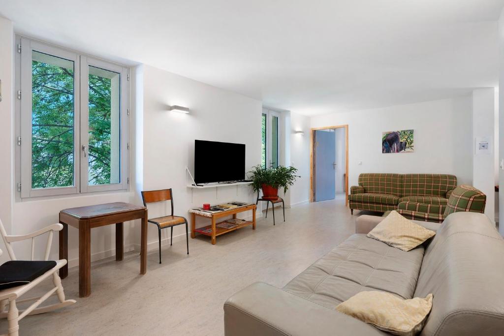 a living room with a couch and a tv at L'auberge le Toit Vert in Moutiers