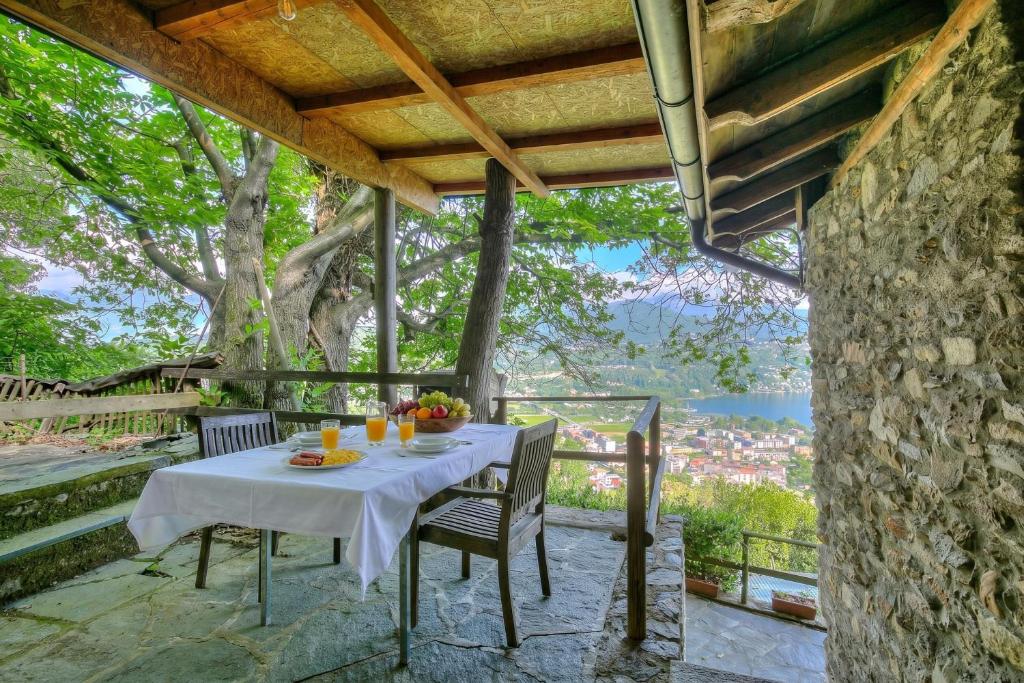 a table and chairs on a patio with a tree at La Capannina Lake & Mountain Views - Happy Rentals in Cimo