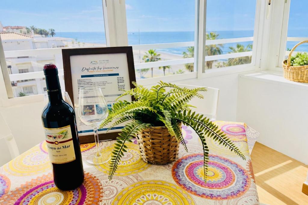 a bottle of wine sitting on a table with a plant at Capri 403 in Torrox Costa