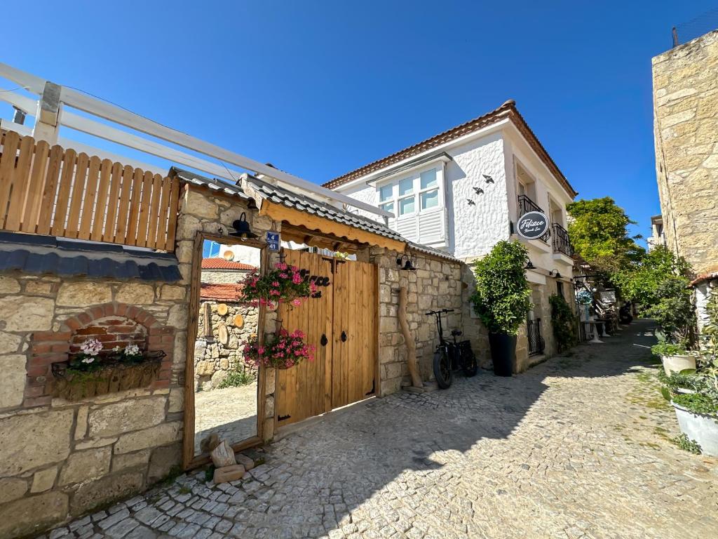 a stone building with a wooden gate in a street at Filizce Alaçatı in İzmir