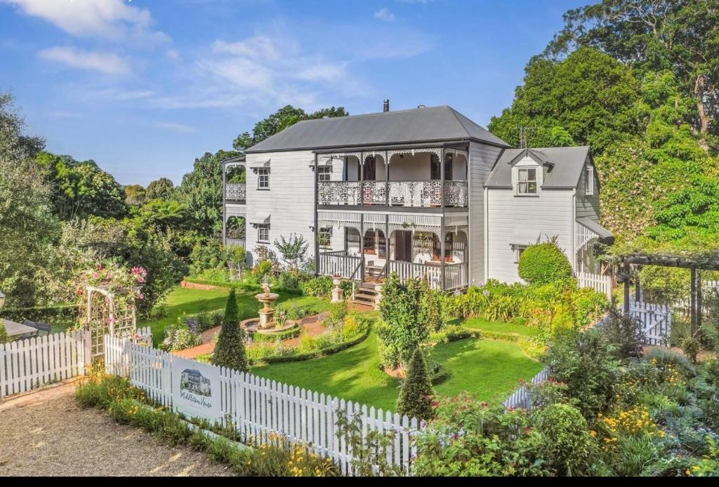 a house with a white fence and a garden at Middleton House Maleny in Witta