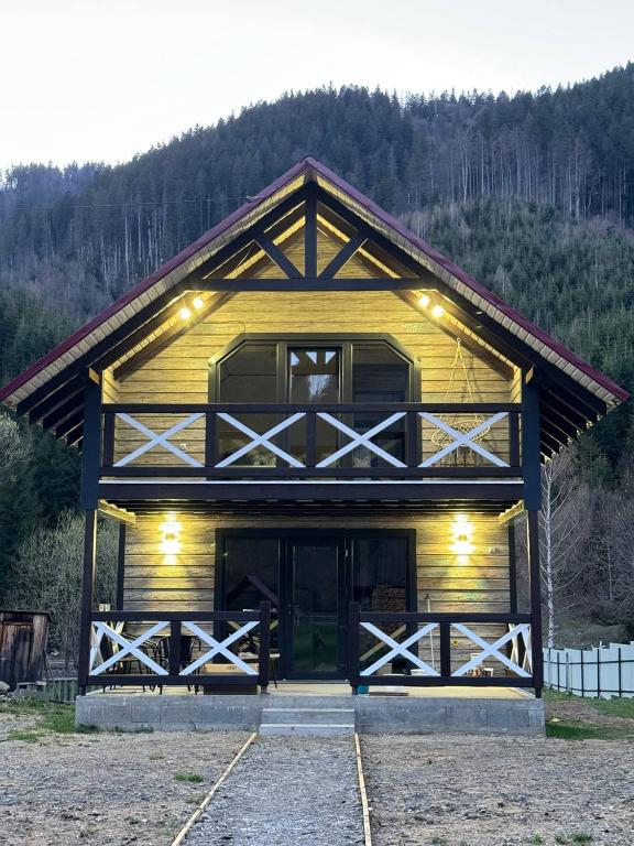a large wooden barn with its doors open at Котедж у Софійки in Synevyrsʼka Polyana