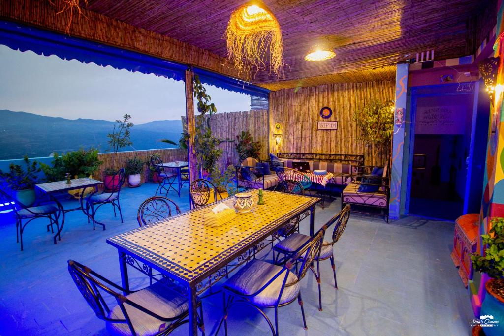 a patio with a table and chairs and a fireplace at Casa Voyager 'secret garden terrace' in Chefchaouen