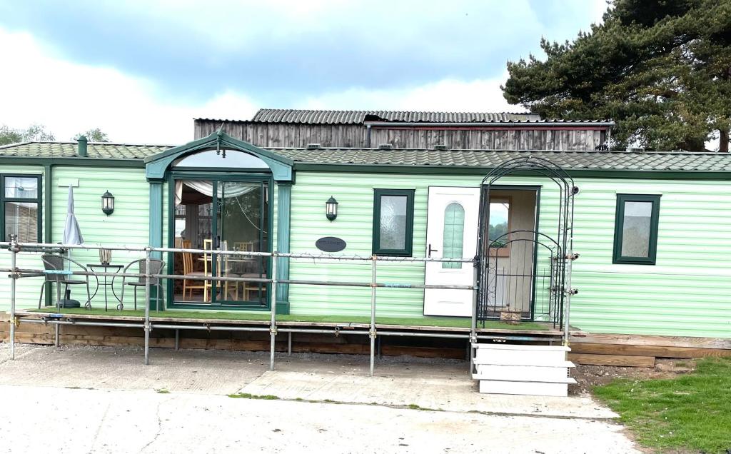 a green train car parked in a parking lot at Sun rise in Macclesfield