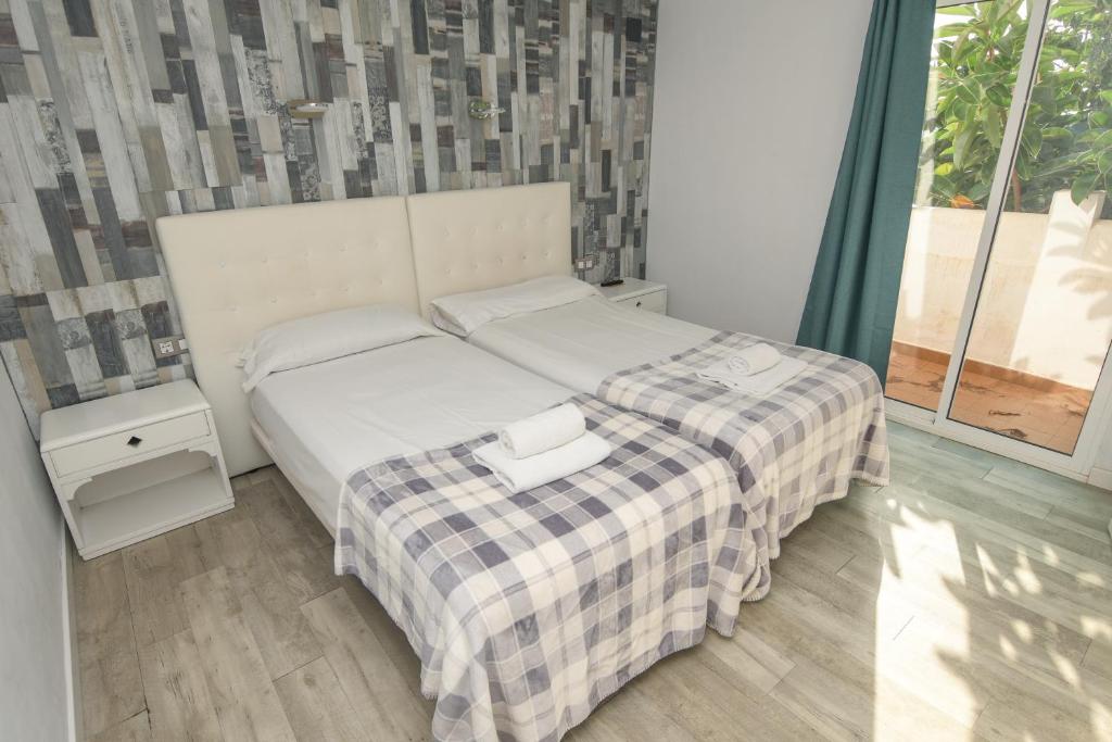 a bedroom with a white bed with a plaid blanket at Home D'or in Cala d´Or