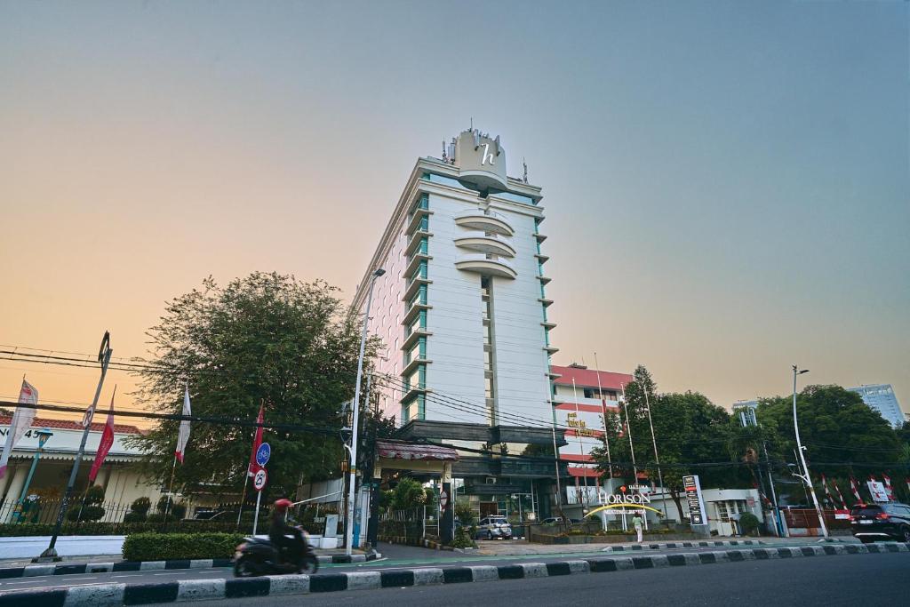 a tall white building on the side of a street at Horison Ultima Menteng Jakarta in Jakarta