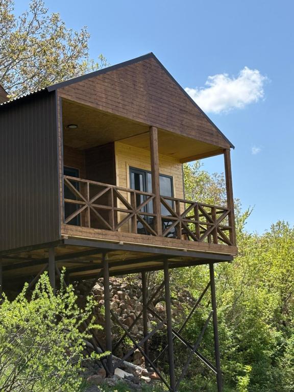 a tree house with a large balcony on a platform at Old Byurakan Cottage in Byurakan