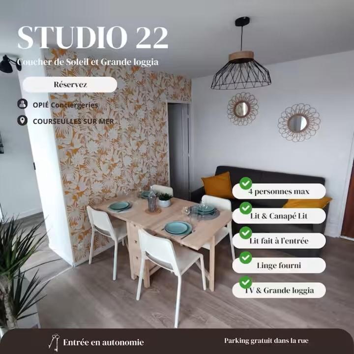 a dining room with a table and chairs in a room at Vue Mer sur Juno Beach - Studio in Courseulles-sur-Mer