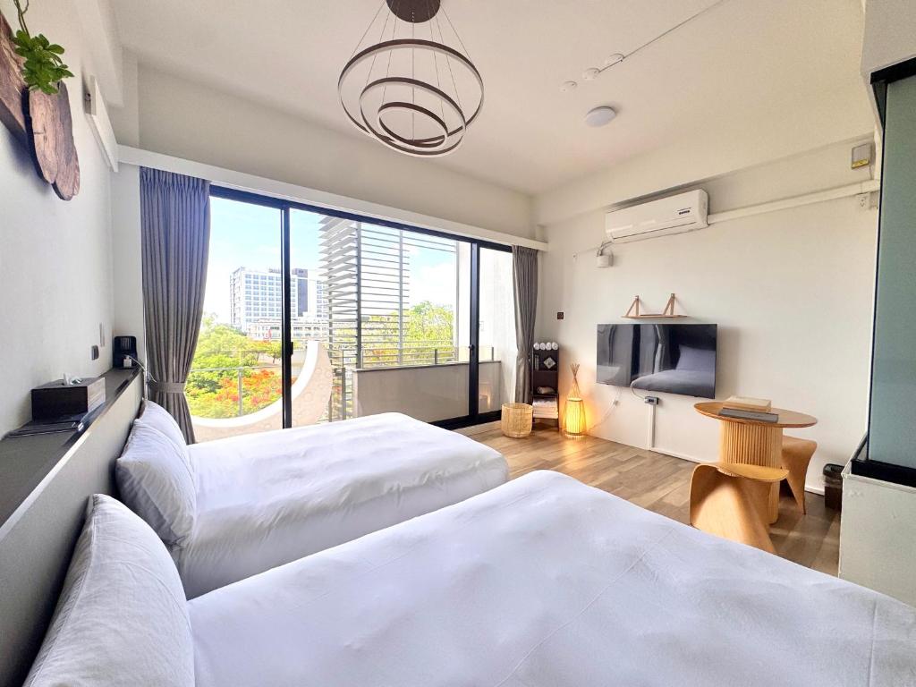 a hotel room with two beds and a flat screen tv at 安平胡桃民宿-免費停車-專屬電梯-公園景觀 #包棟可使用娛樂設施 in Tainan