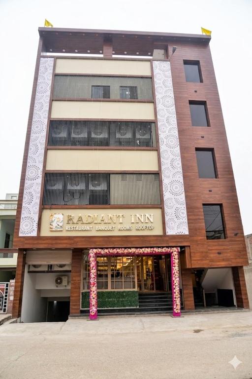 a tall building with a sign on the front of it at Hotel Radiant Inn in Morena