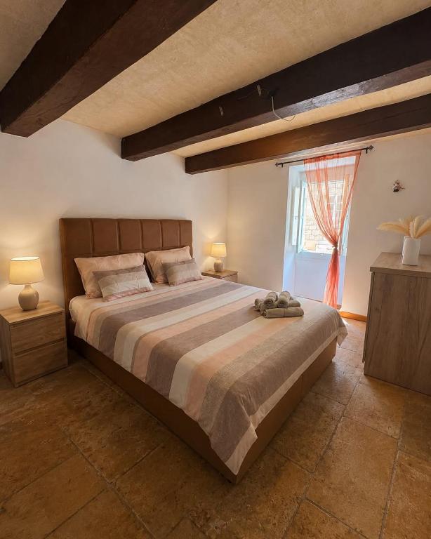 a bedroom with a large bed and a window at Republic Stay in Valletta