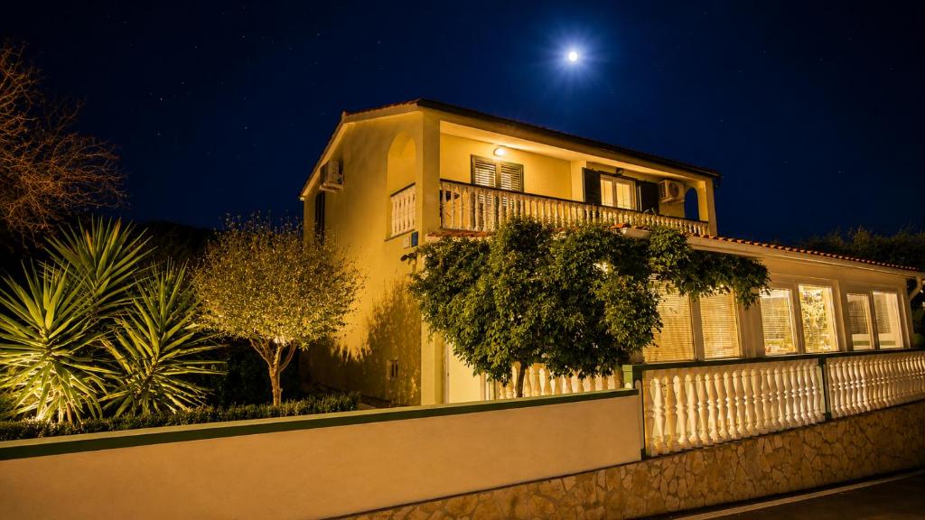 a large yellow house with a fence in front at Apartment Pelicaric Sali Dugi otok in Sali
