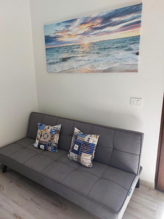 a couch in a living room with a painting on the wall at Domus Vida in Quartu Sant'Elena