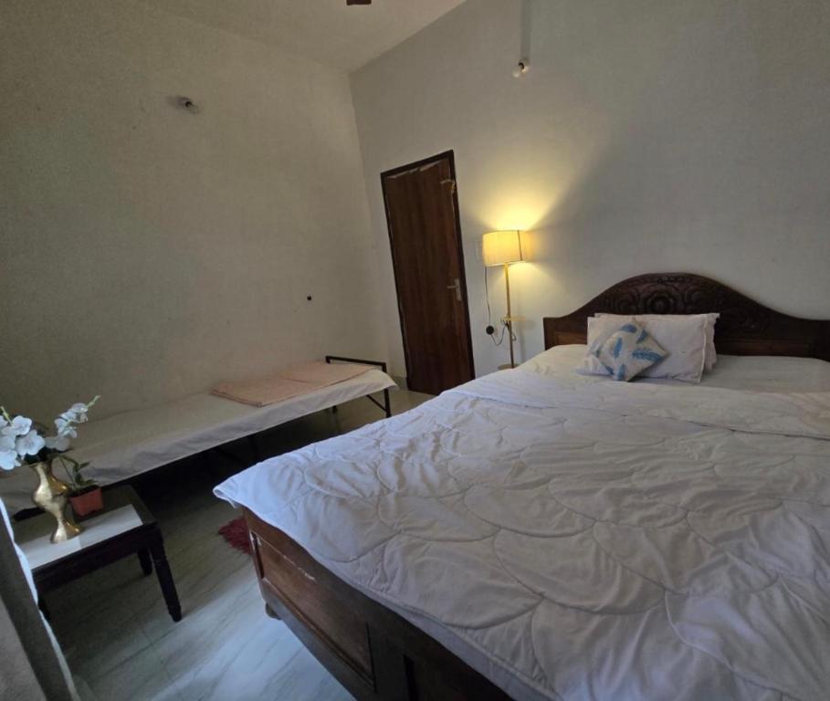 a bedroom with a large bed and a bench in it at SS Hostel Siliguri in Siliguri