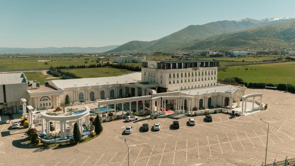 an aerial view of a large white building with cars parked outside at Alegria Hotel in Prizren