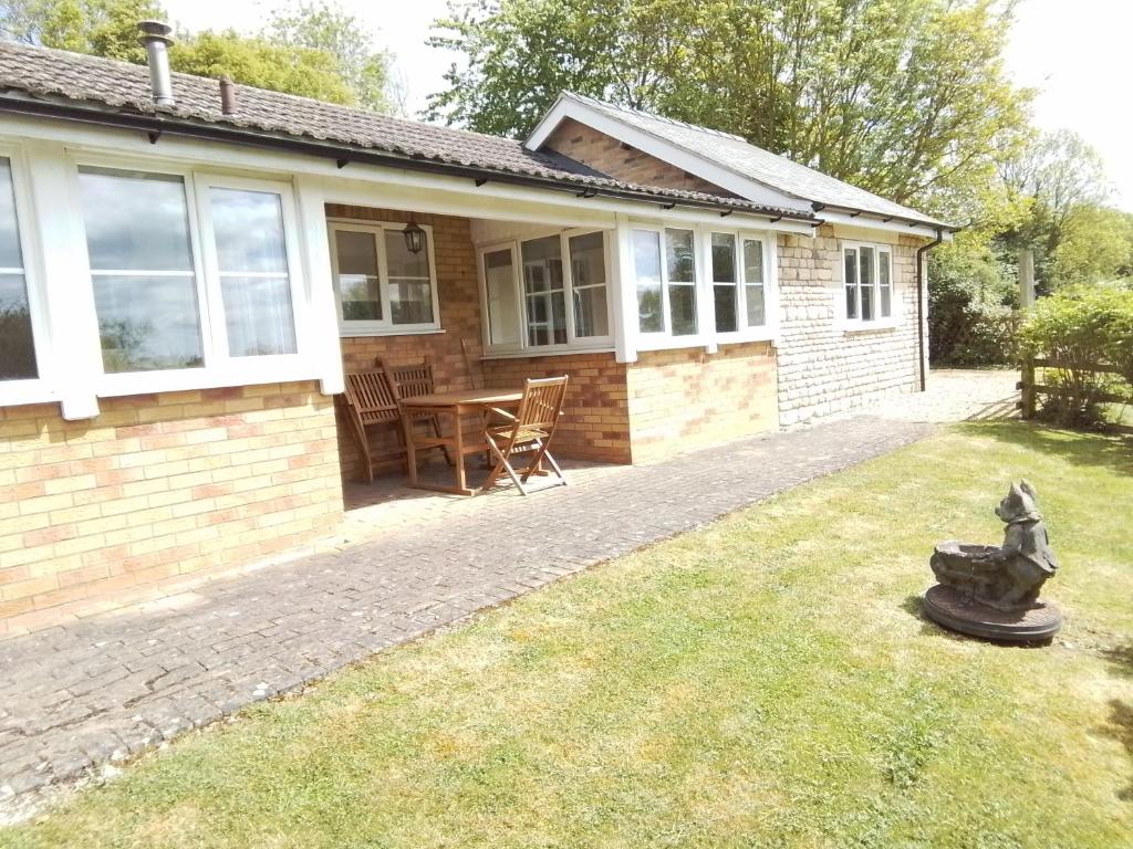 a house with a table and chairs in the yard at Elderflower Cottage in Stamford
