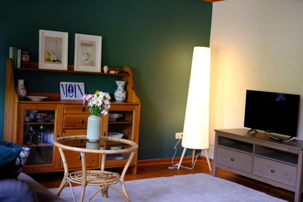 a living room with a vase of flowers on a table at Judies Garten in Schaalby