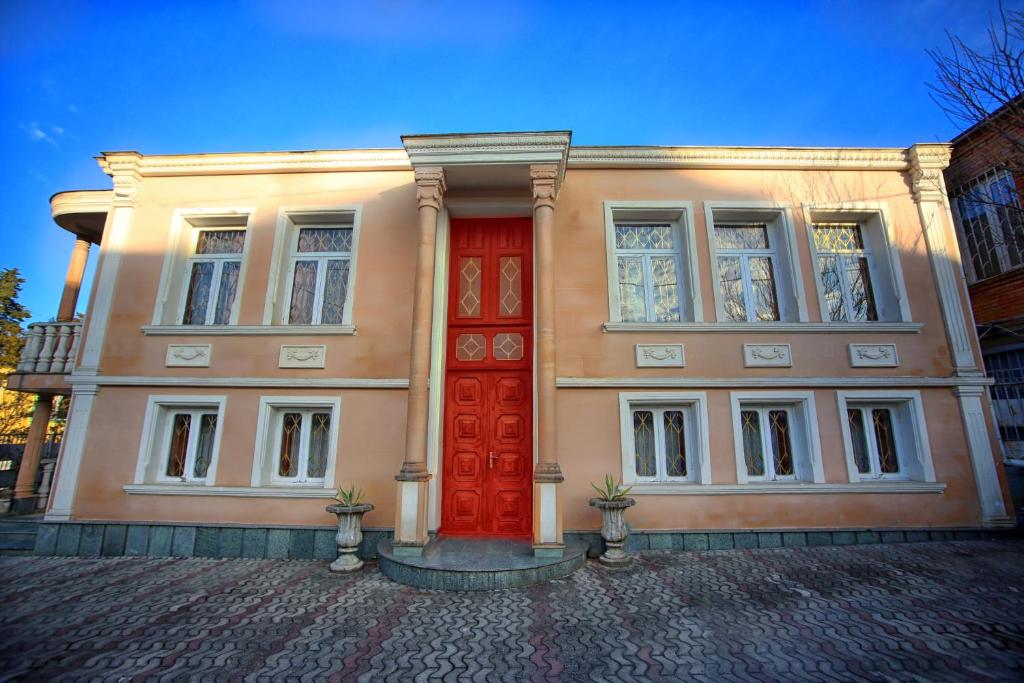 budynek z czerwonymi drzwiami na ulicy w obiekcie Apartment Gardenia w Kutaisi