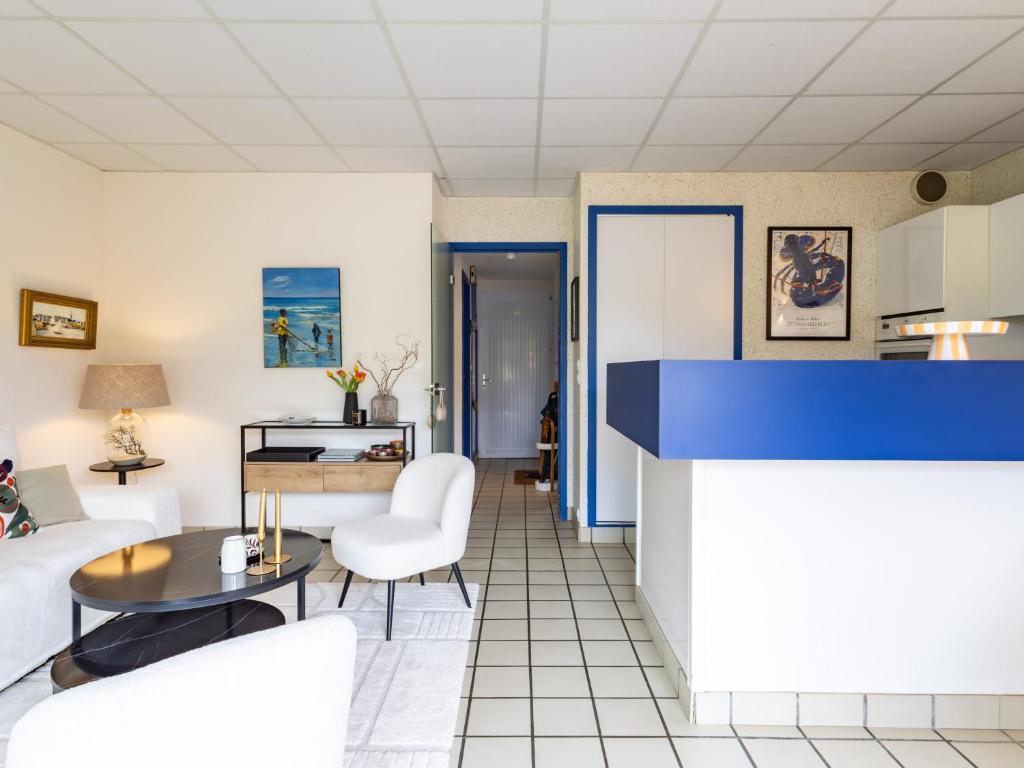 a living room with white chairs and a table at Ker Envor in Pleumeur-Bodou