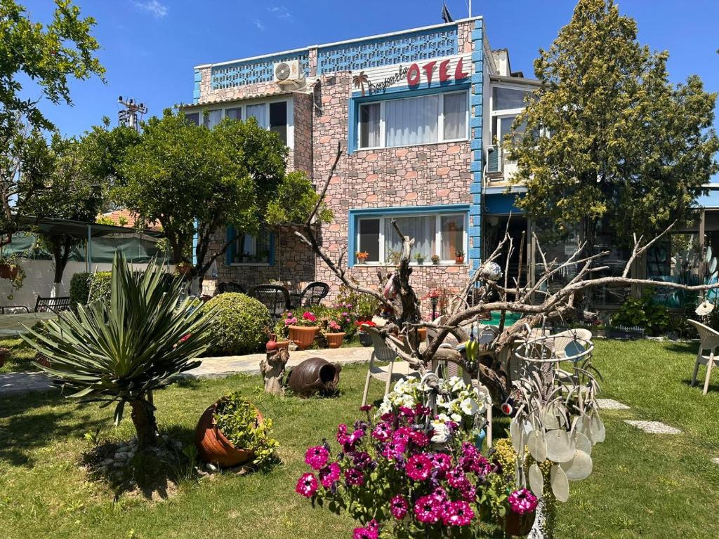 a garden with flowers in front of a building at Bonjourla Otel in Urla