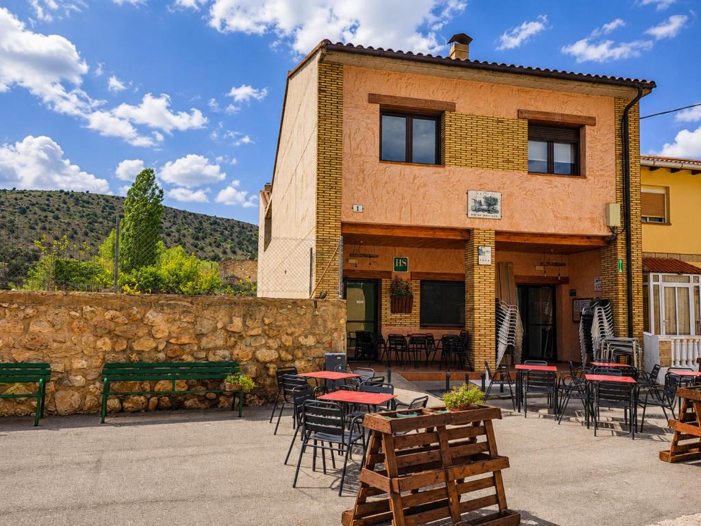 a building with tables and chairs in front of it at Hostal Restaurante Monterde de Albarracín in Monterde de Albarracín