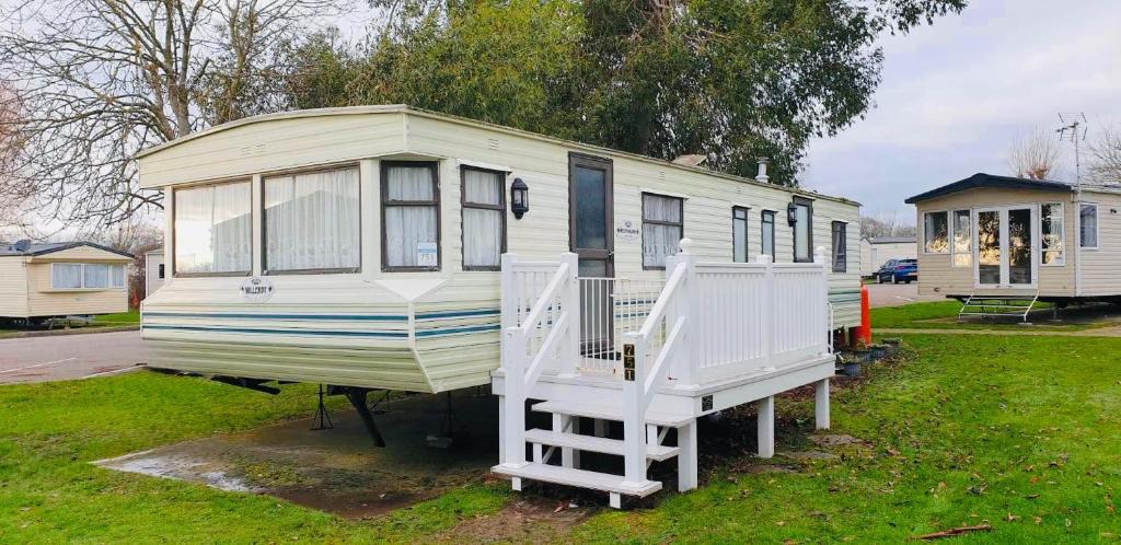 a mobile home with a porch and two stairs at Static Caravan Sleeps 8 with Indoor Pool in Clacton-on-Sea
