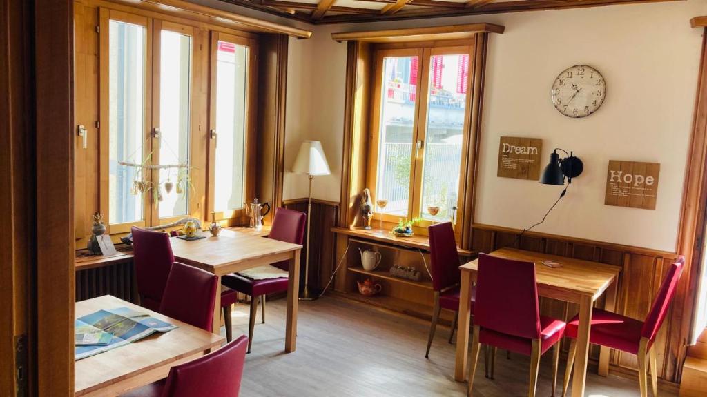 a dining room with wooden tables and chairs and windows at Bio Bed & Breakfast Froschkönig in Gersau