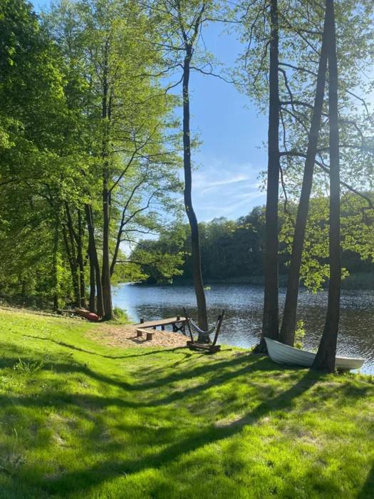 a picnic table and a bench next to a lake at Zacisze domek z Jacuzzi & Sauna in Chrołowice
