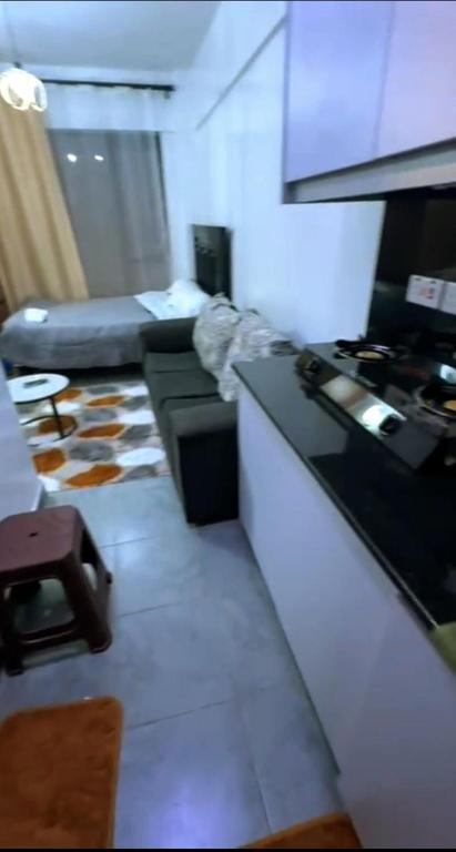a kitchen with a stove and a couch in a room at Tembea Stays in Kiambaa