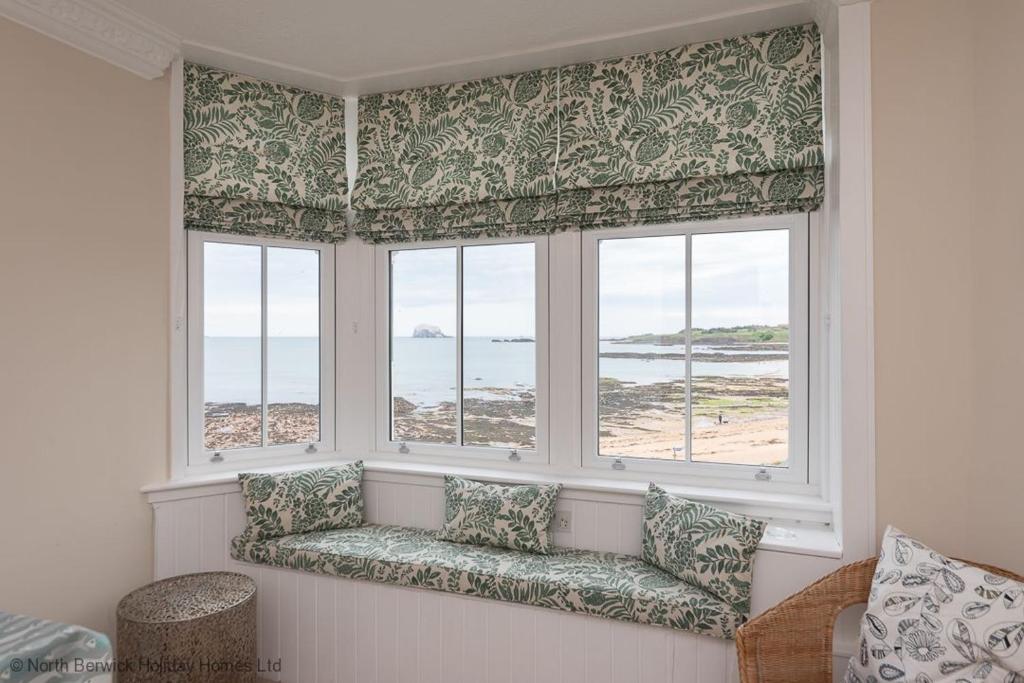 a window seat in a room with a view of the ocean at Bass Rock View in North Berwick