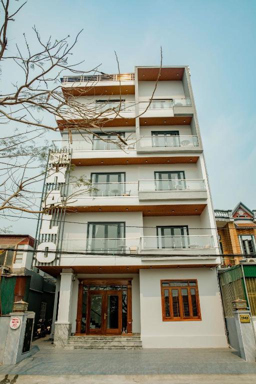 a tall white building with a door in front of it at Halo Motel Đồ Sơn in Ðố Sơn