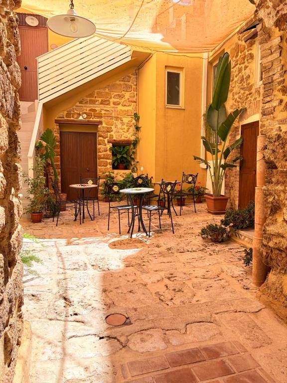 a patio with a table and chairs and a building at BeB Omare Agrigento in Agrigento