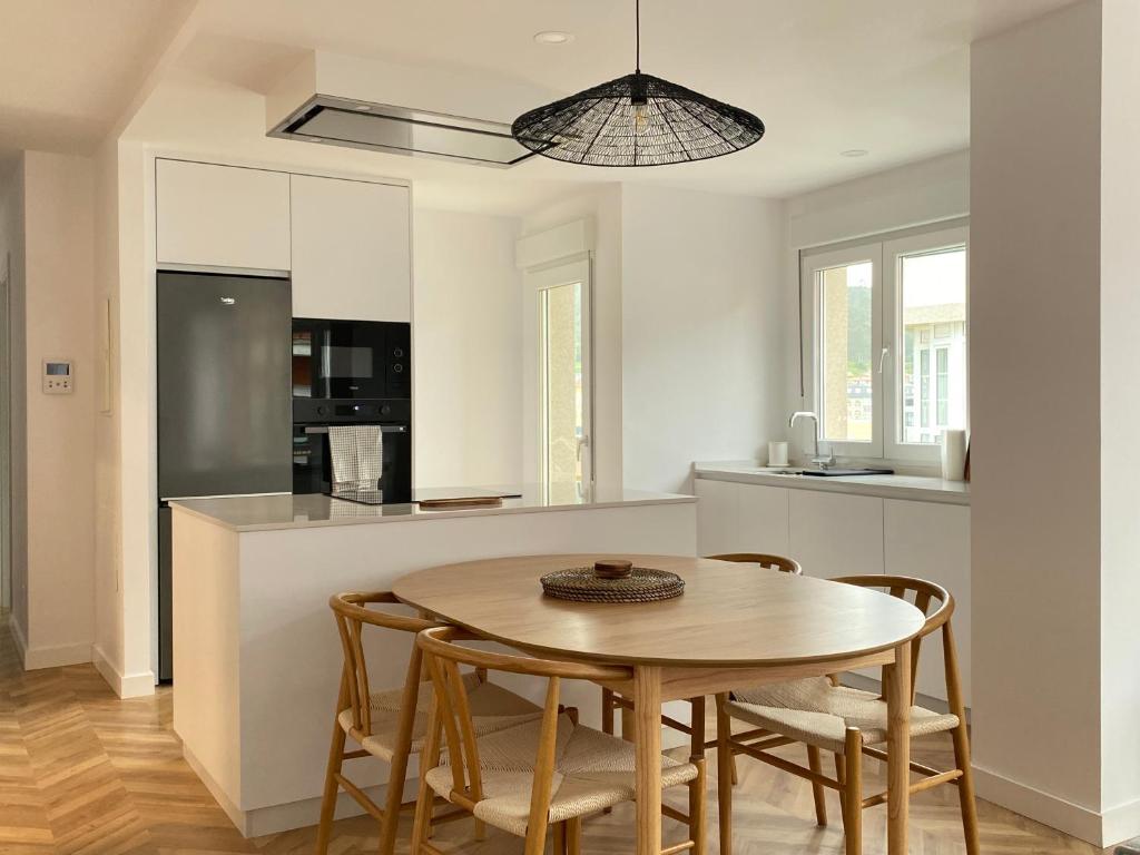 a kitchen and dining room with a table and chairs at Praia - Boa Onda in Cee